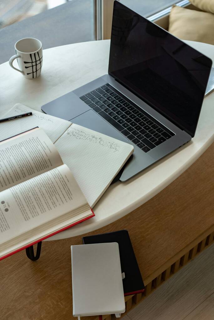 Laptop and books on table